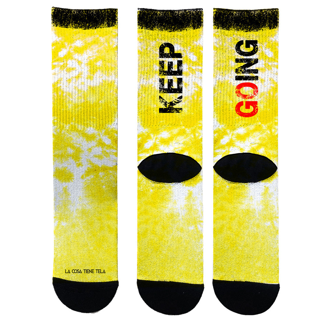 Parte delantera y trasera calcetines amarillos vibrante con el mensaje motivacional "Keep Going" en la parte superior, diseñados para inspirar y mantener la motivación durante tus entrenamientos.
