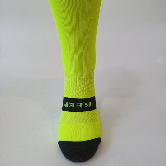 Parte delantera calcetines técnicos de alto rendimiento amarillos, fabricados con materiales termorreguladores que ofrecen transpirabilidad, soporte y comodidad durante actividades físicas intensas.
